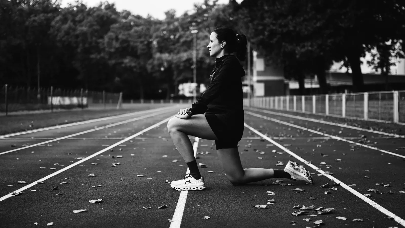 Bruna, Co-Founder und Running Coach bei augo, beim Dehnen auf einer Laufbahn